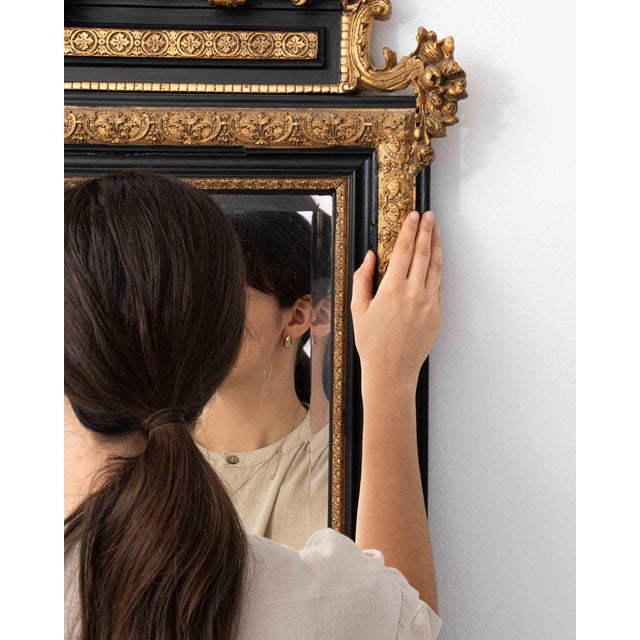 This mirror makes its impression through dark wood frame with gilt crest, ornate. It was made in France during 1880s, a...