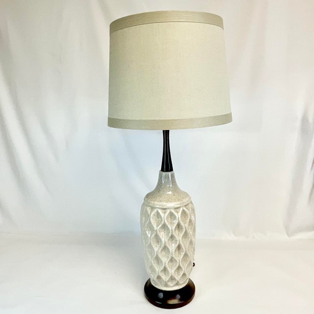 Offering a stunning Mid-Century Tall Ceramic and Walnut Table Lamp. The ceramic body features a detailed geometric design...