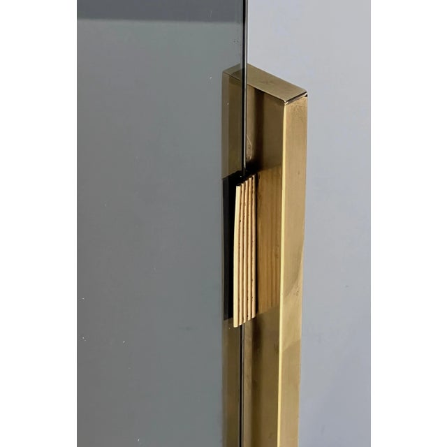 This very nice and unusual fireplace screen is made of brass with smoked glass. This is a French work, circa 1970.