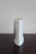 A bud vase in porcelain by virebent, made in france in the 1970s. The flattened pebble body rises to a small round...