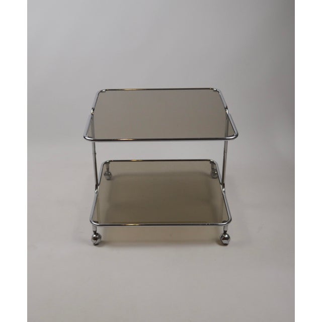 Elegant Italian coffee table produced in the 1970s, featuring a minimalist chromed metal tubular structure mounted on four...