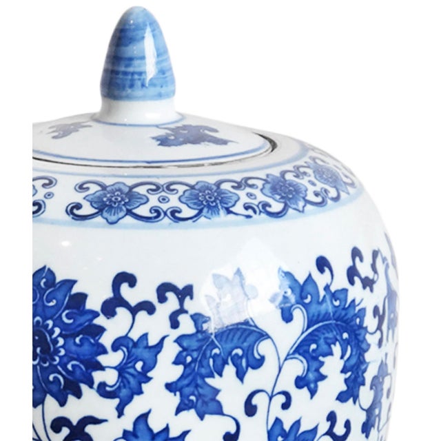 Vintage lidded ceramic jar featuring a beautifully balanced silhouette adorned in an intricate cobalt blue floral motif...