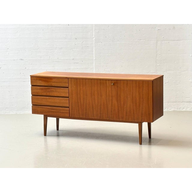 A generously proportioned sideboard from the 1960s, crafted from high-quality teak. The clean, horizontally structured...