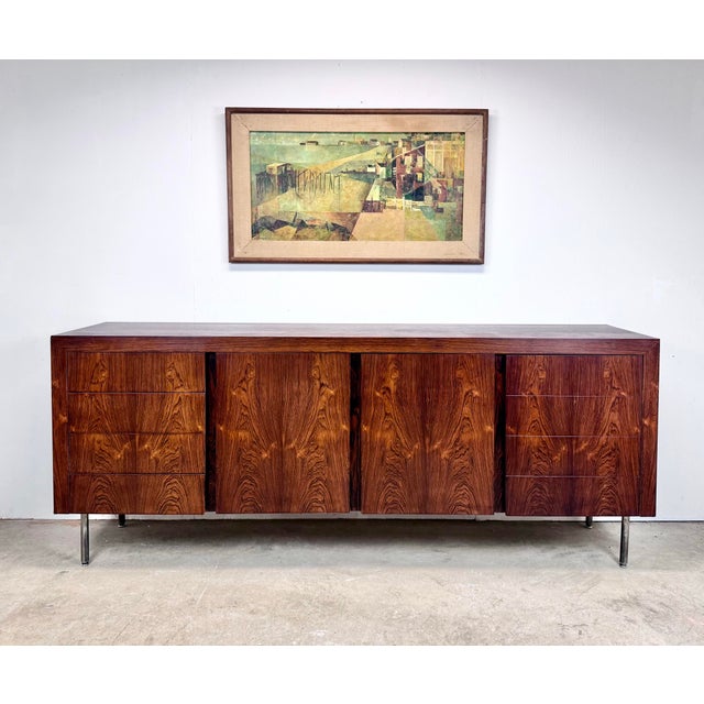 A stunning mid century modern rosewood credenza on chrome steel legs circa 1970’s. Features beautifully figured wood grain...
