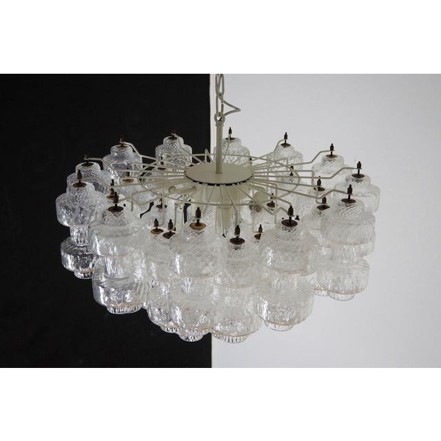Italian vintage chandelier in Murano glass and white painted metal structure. The armor polished nickel supports 37 large...