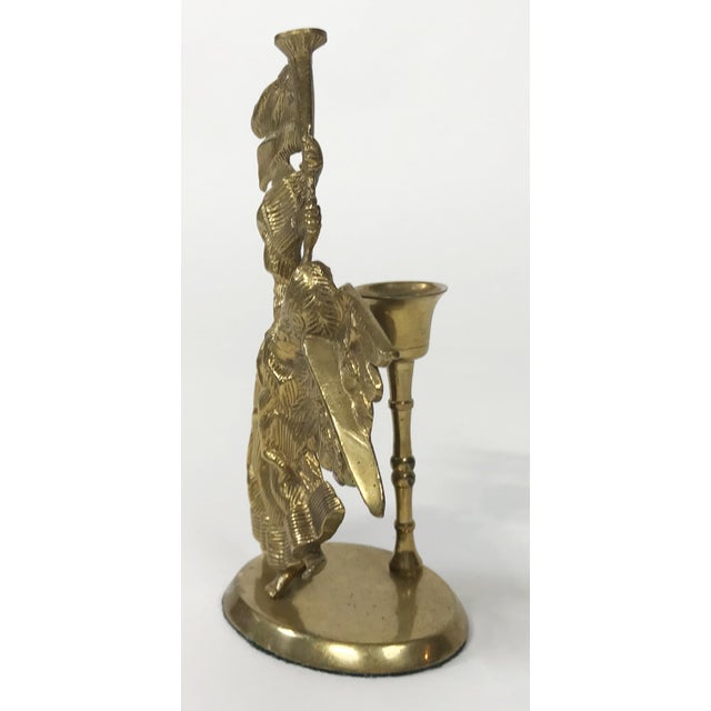 Vintage brass candlestick featuring a winged angel blowing a horn. She has great presence in her flowing gown and large...