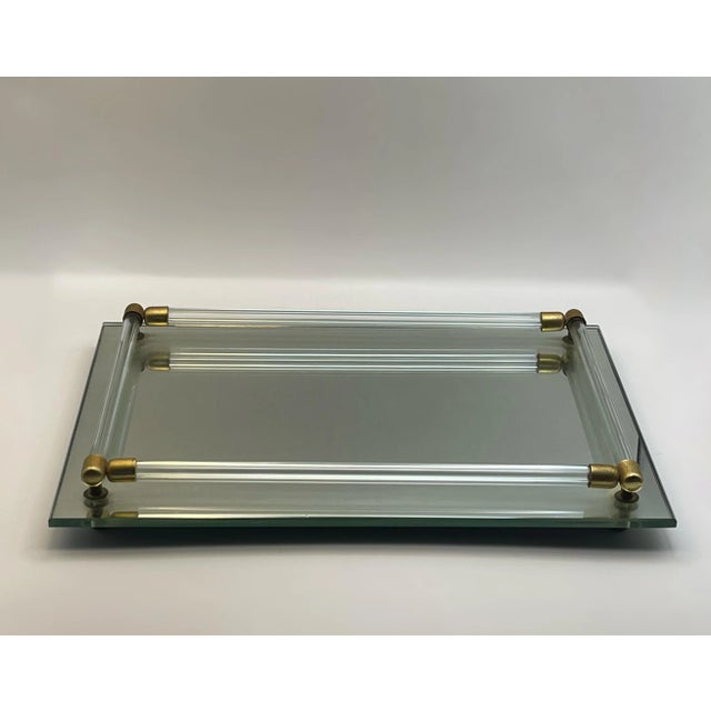 A mirrored vanity tray with glass rails capped with brass made in the late twentieth century.