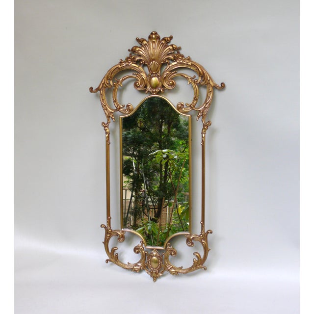 An elegant bronze wall mirror, made in France. The mirror is marked twice on the back with MOD DEP. The bronze frame is...