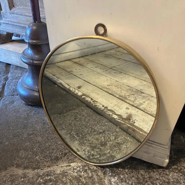 A solid brass wall mirror designed and manufactured in Italy in the Fifties in the manner of Gio Ponti, it's in good...