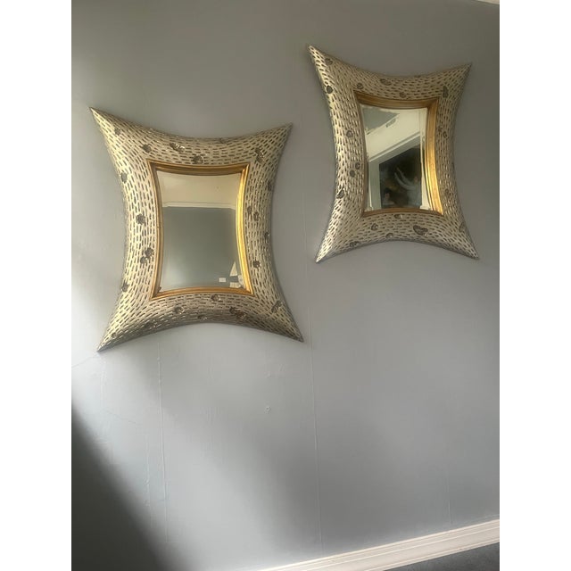 A striking pair of sculptural four-point mirrors attributed to the style of Christopher Guy. Each frame showcases an...