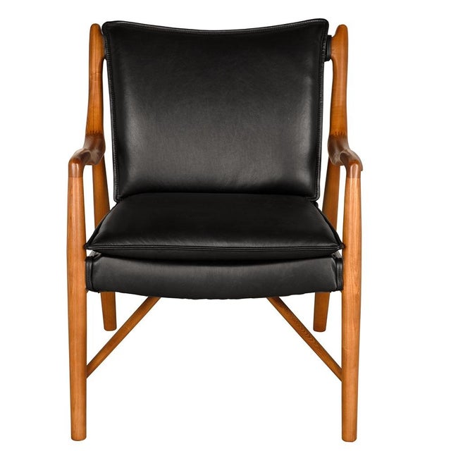 This accent armchair, inspired by mid-century design, features a sculptural wood frame with elegant, flowing arms....