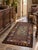 An antique hand-hooked rug featuring a stylized green floral motif against a muted brown field, framed by a colorful...