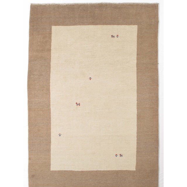 Vintage hand-knotted Persian Gabbeh rug featuring a deep blue field with subtle tonal variation and scattered small tribal...