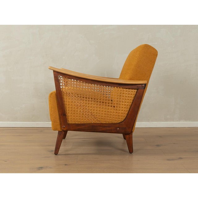 A wonderful armchair from the 1950s. High-quality beech frame with rattan weaving on the sides. The original spring core...