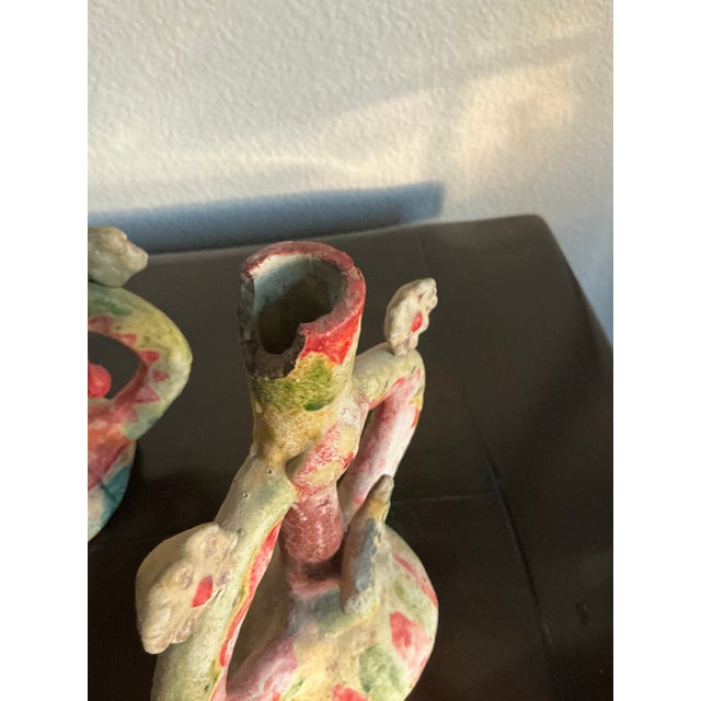 A charming and highly unusual pair of vintage Mexican folk art pottery candleholders, handcrafted and painted with...