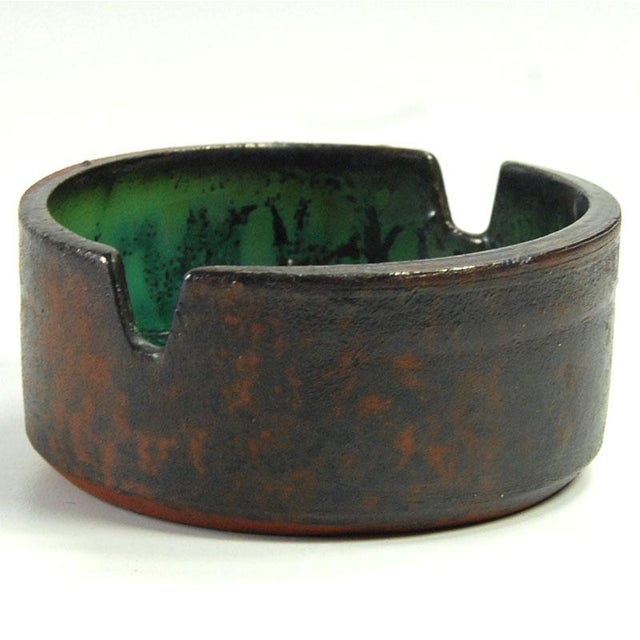 A unique, small ashtray, handcrafted from ceramic. The exterior is raw clay finished with a transparent glaze. The...