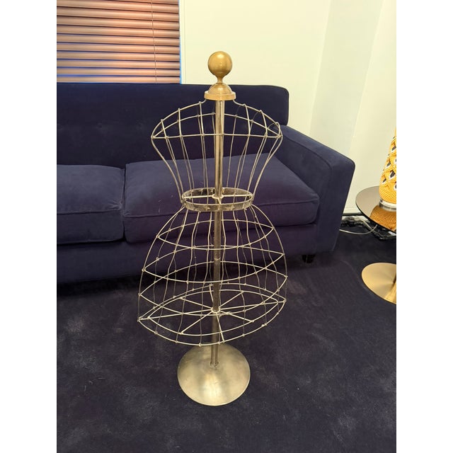 This charming antique French iron dress form features a sculptural wire silhouette with a rounded finial top and circular...