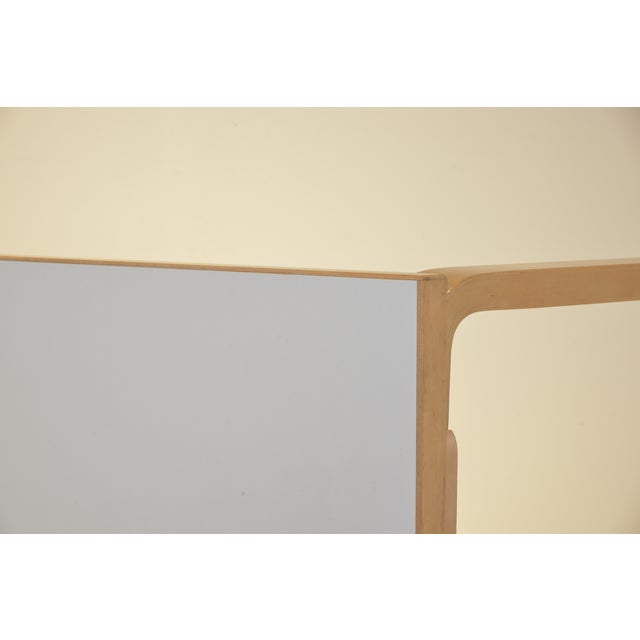 The 81A table is a timeless design by Alvar Aalto from 1935. This rectangular dining table combines a solid birch frame...