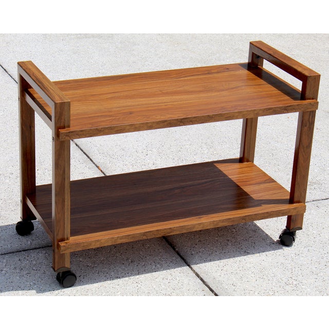 A classic slice of Mid-Century design, this vintage cart by Gusdorf blends clean lines, warm walnut tones, and effortless...