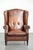 This sheepskin wingback chair is crafted in a warm cognac color and features a refined finish with decorative studs. The...