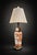 Elegant vintage porcelain table lamp featuring a detailed floral and botanical design in warm terracotta tones over a...