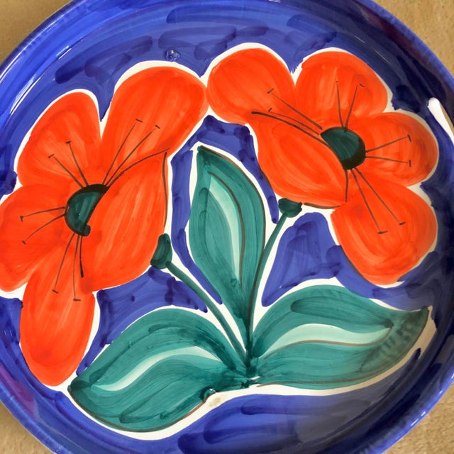 An Italian pottery tray with red flower design on a blue background by Bellini.