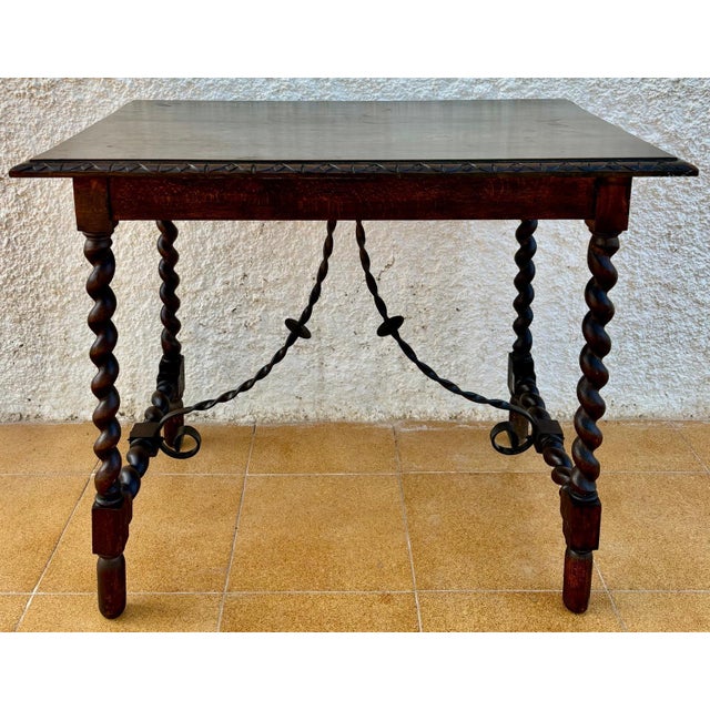 19th Spanish side table with cared Solomonic turned legs and iron stretcher. The top has a carved edges and a beautiful...