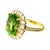 Cocktail ring crafted in 18k yellow gold, featuring a central cushion-cut peridot. The peridot is surrounded by a halo of...
