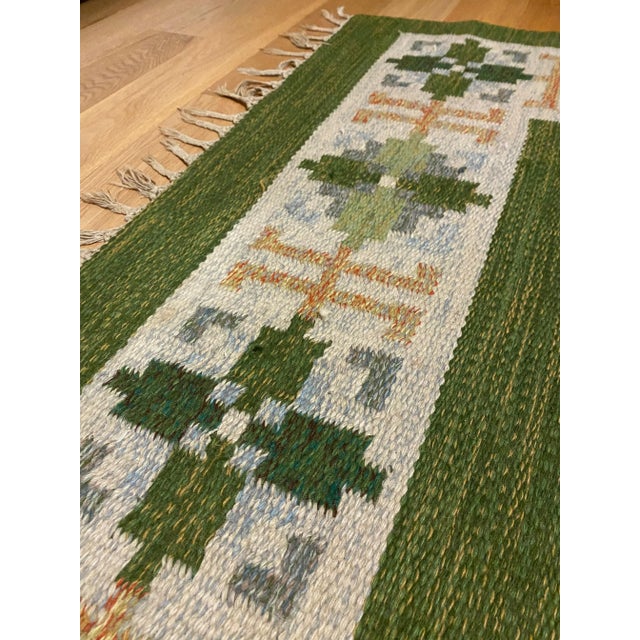 Beautiful Vintage Swedish Green Rölakan rug by Fredrik Fiedler. In a good vintage condition with some wear and tear to the...