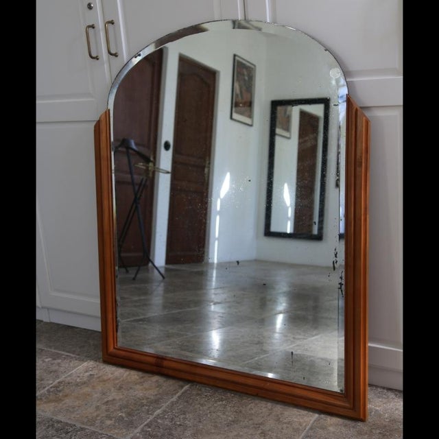 Large arched wall mirror, designed in the 1950s and inspired by Art Deco lines. Its shape and wooden frame with sculpted...