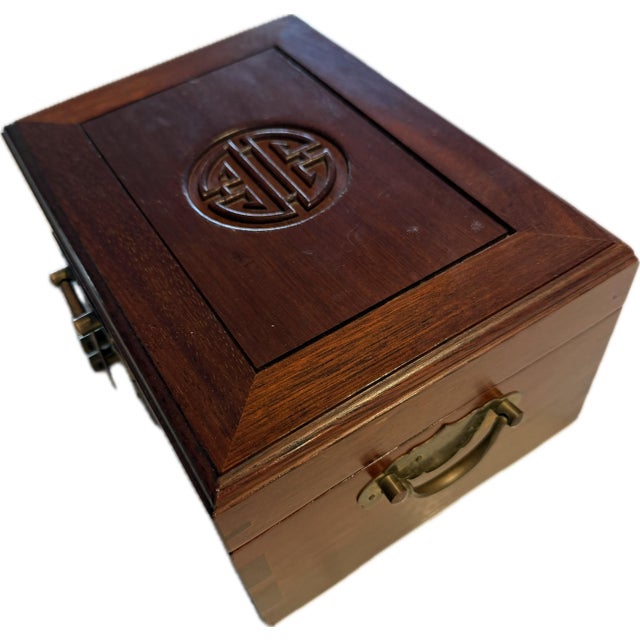 This is a vintage Asian-style wooden jewelry box. It features a rich, dark wood finish. The top is decorated with a carved...