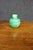 Handcrafted ceramic vase in a rounded form with a short cylindrical neck, finished in a rich green glazed surface. The...