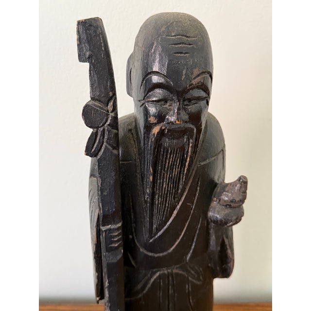 Early 1900s hand-carved antique wooden statue of Shou Xing, the Chinese god of longevity. Holding a peach in one hand and...