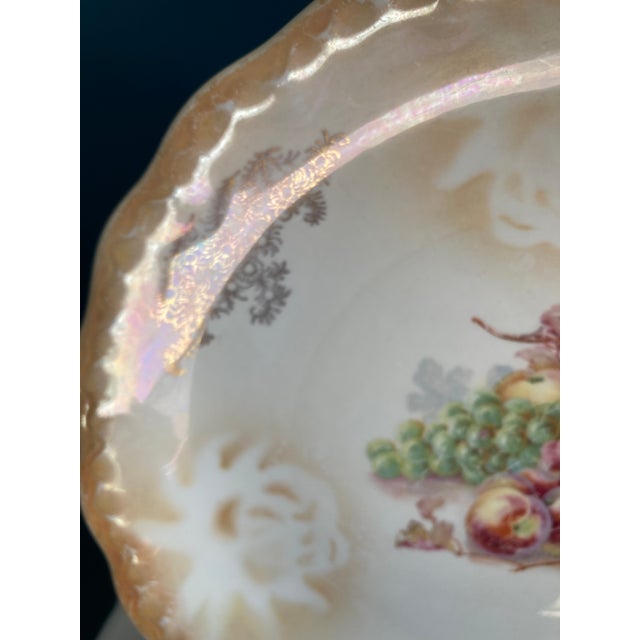 This antique decorative plate by D.E. McNicol features a softly scalloped edge, creamy ivory glaze, and a finely detailed...