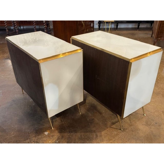 This product is a stylish pair of modern white Murano glass and brass bedside tables. The sleek design features shimmering...