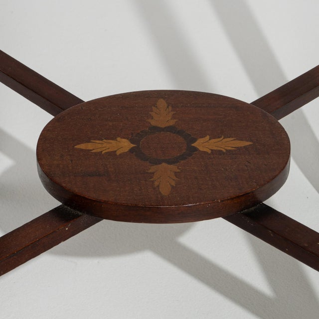 A 19th century English side table featuring an oval top with inlaid detailing and a slender supporting structure. The...