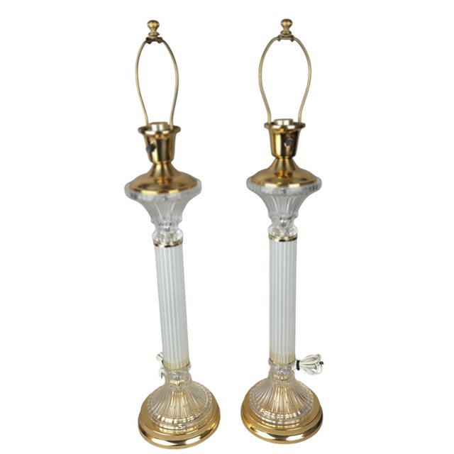 A matching pair of vintage Hollywood Regency-style buffet/table lamps featuring fluted glass columns with clear and...