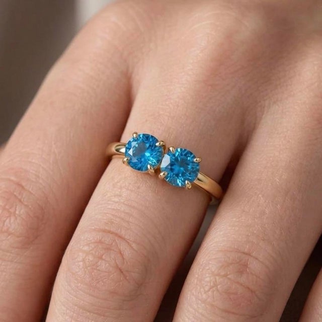 Dive into a world of serene, captivating brilliance with this exquisite 18k gold-plated two-stone ring. Featuring a pair...