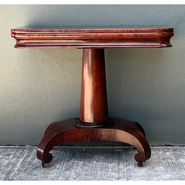 This exquisite antique flip-top games table is a testament to 19th-century craftsmanship, featuring a breathtaking flame...