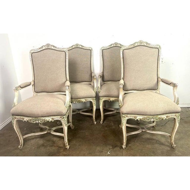 Set of four Painted French Louis XV style armchairs. The armchairs are upholstered in a washed Belgium linen with nailhead...