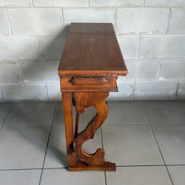 Elegant and versatile solid wood console table with a central drawer and lyre-shaped legs, a solid piece of cabinetry...
