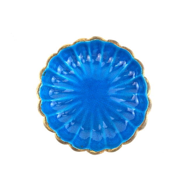 A striking vintage Italian art pottery bowl featuring a brilliant blue crackle glaze contrasted by a hand-gilded exterior....
