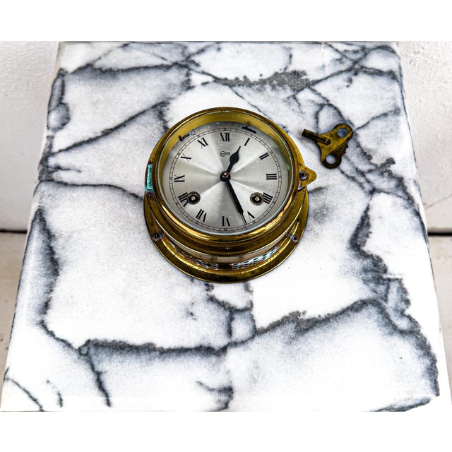 A brass Barigo German ship's clock with Roman numeral dial, a working hinge and latch, clear glass face, and original...