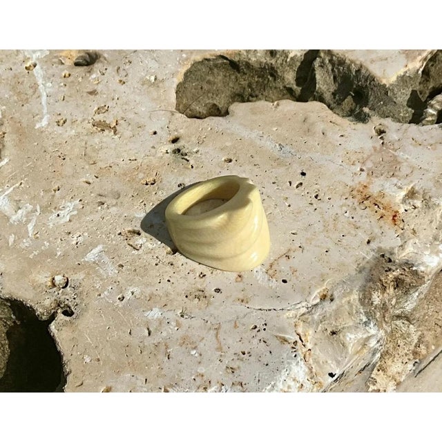 This vintage ring is a chunky, sculptural band in smooth, glossy ivory-toned material, shaped like a soft, tapered dome....