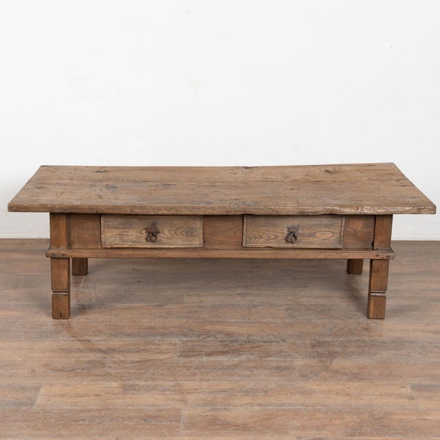 Late 19th century French coffee table, crafted in oak. The table features two drawers fitted with iron pulls, adding...