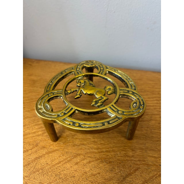 This vintage English brass trivet carries with it the unmistakable spirit of the countryside. At its center, a lively...