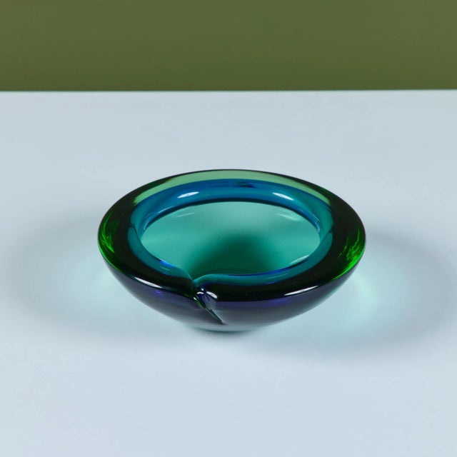 Italian Murano round glass ashtray or catchall, showcases a rich jewel tone in blue and green glass. This piece has a wide...