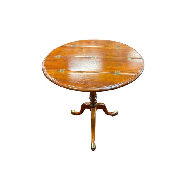 Capturing the essence of 19th-century British Colonial design, this Campaign-style tripod table by Theodore Alexander...