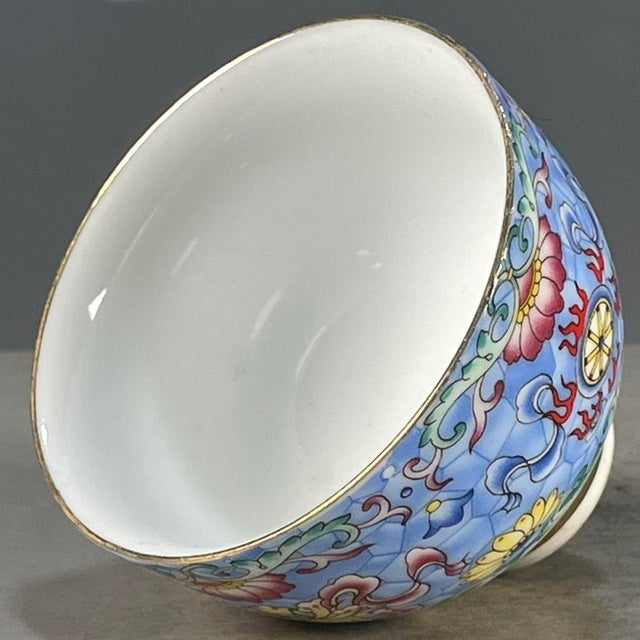 This is a charming vintage Chinese porcelain teacup, decorated in the famille rose (五彩) palette with vibrant polychrome...