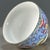 This is a charming vintage Chinese porcelain teacup, decorated in the famille rose (五彩) palette with vibrant polychrome...